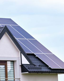 Residential house with rooftop covered with solar photovoltaic panels for producing of clean ecological electrical energy in suburban rural area. Concept of autonomous home